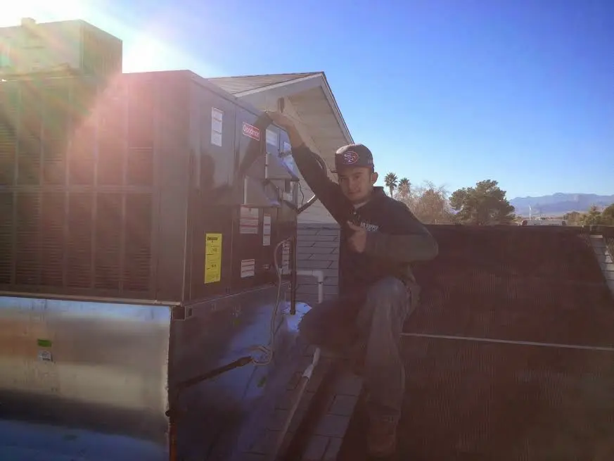 HVAC technician performing AC Tune-Up on a rooftop unit in Los Banos